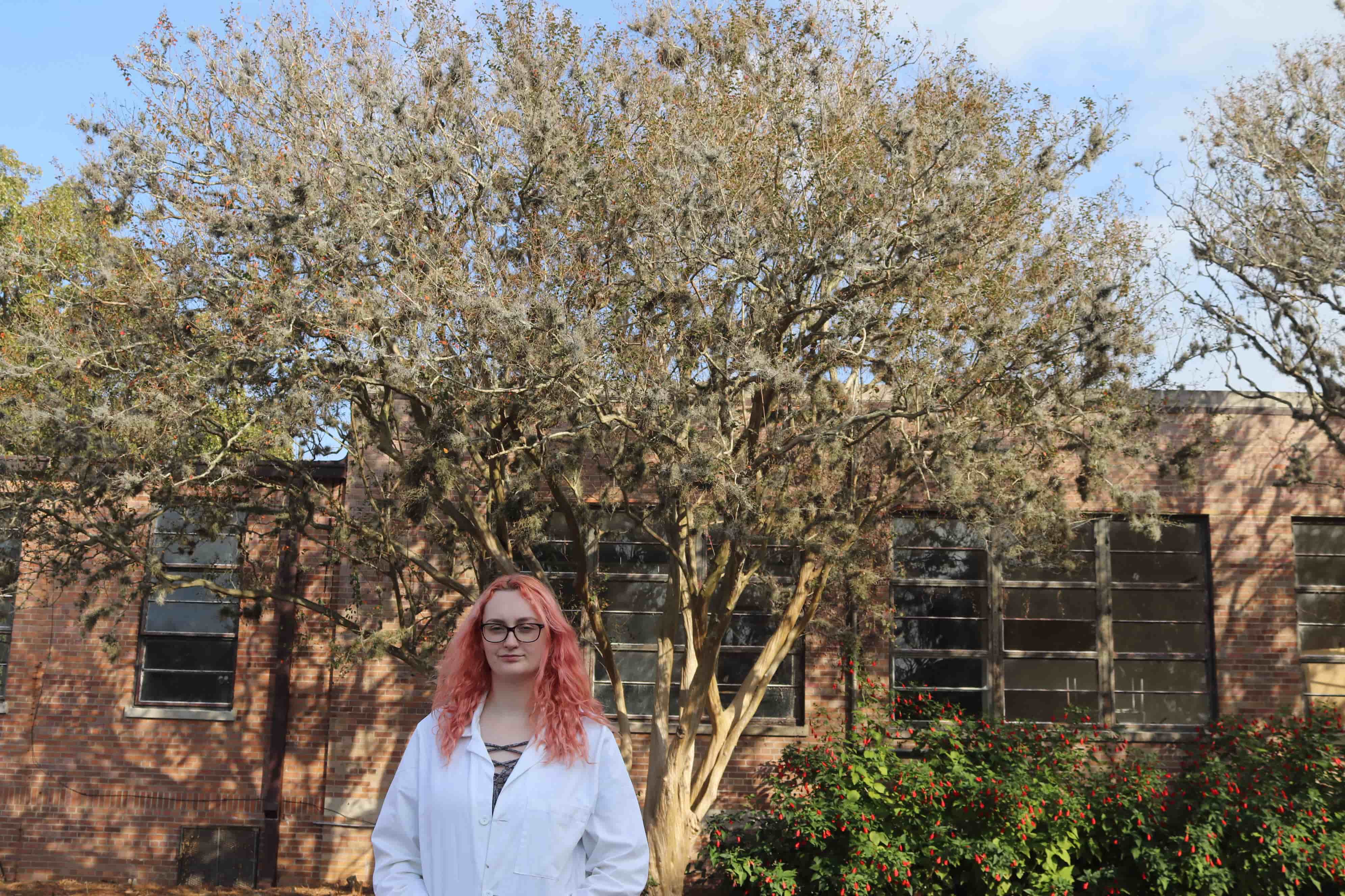 Kali Elftman standing in front of a tree covered in ball moss.