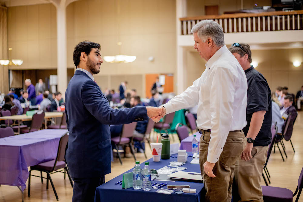 student shaking hands with employer