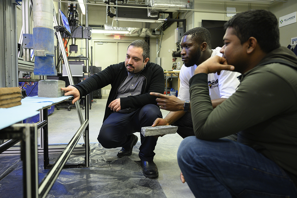 Ali Kazemian shows students layers of 3D constructed concrete