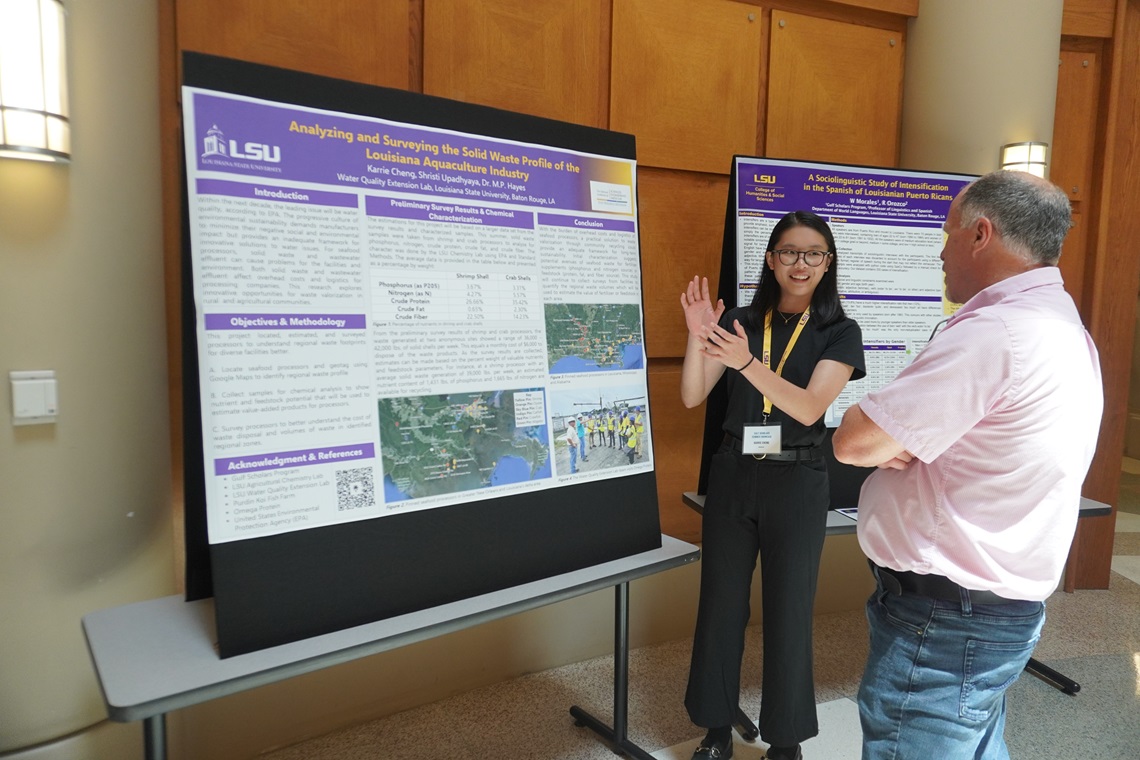 Student presenting a research poster to a faculty member