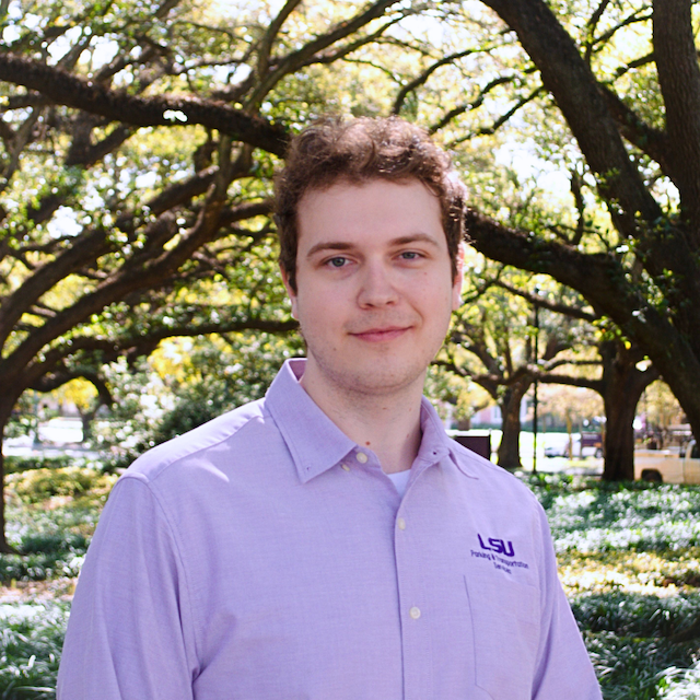 man somewhat-smiling in purple polo